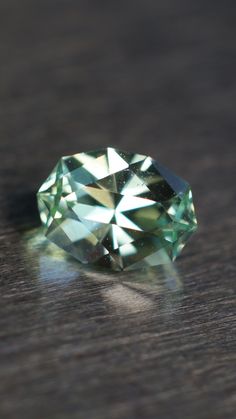 a green diamond sitting on top of a wooden table