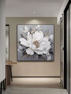 a large white flower is hanging on the wall in this modern entryway with black and beige accents