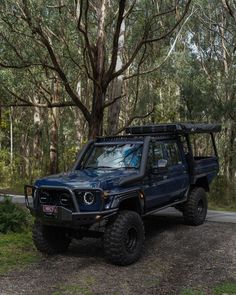 a blue four - doored off road vehicle parked in the woods