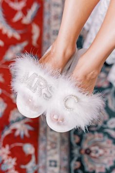 a close up of a person's feet wearing fluffy white slippers with the word bride written on them