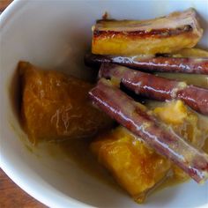 a white bowl filled with food on top of a wooden table