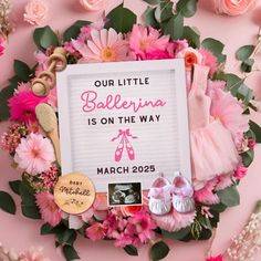 a sign that says our little ballerina is on the way and surrounded by pink flowers