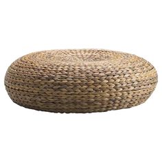 a large round woven ottoman sits on the floor in front of a white background,