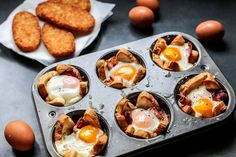 some eggs are in a muffin tin next to some fried chicken and other food