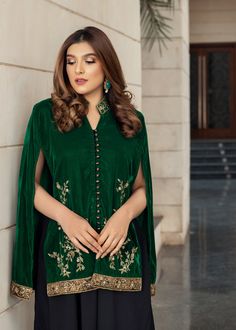 Emerald green velvet cape handworked with dabka, tilla and zardozi with accents of jamawar. Paired with black flared pants and an inner slip. A very chic and trendy outfit for the winter weddings or festivities. (Includes cape and inner slip) Green Cape Sleeves Sets For Eid, Green Sets With Resham Embroidery And Cape Sleeves, Green Cape Sleeve Sets For Eid, Cape Sleeves Kurta With Dabka Work For Eid, Eid Kurta With Dabka Work And Cape Sleeves, Festive Green Sets With Cape Sleeves, Traditional Sharara With Dabka Work And Cape Sleeves, Bollywood Style Kurta With Cape Sleeves For Party, Bollywood Style Party Kurta With Cape Sleeves