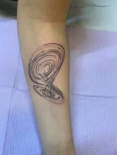 a woman's arm with a tattoo on it that has an image of a spiral design