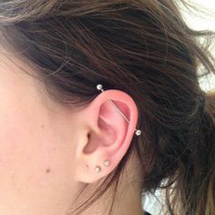 a close up of a person's ear with two piercings on it and one behind the ear