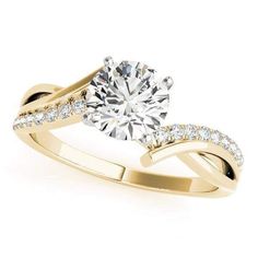 a yellow gold engagement ring with diamonds on the band and a round cut diamond in the center