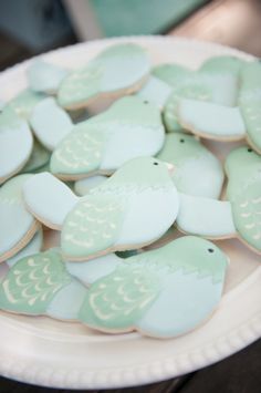 some cookies are sitting on a plate and ready to be decorated with frosted icing