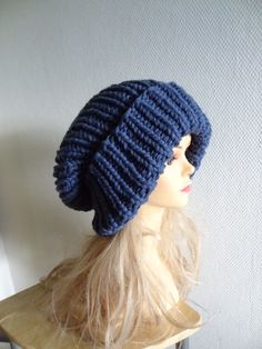 a mannequin wearing a blue knitted hat on top of a wooden table