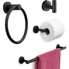 two black towel holders and one pink towel hanging on the wall next to a toilet paper roll