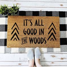 someone is standing in front of a door mat that says it's all good in the woods