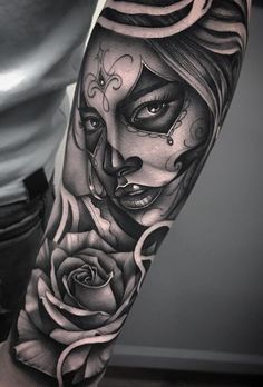 a woman's arm with a rose and skull tattoo on the left side of her body