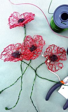 yarn, scissors and spools of thread are laid out on a table with flowers