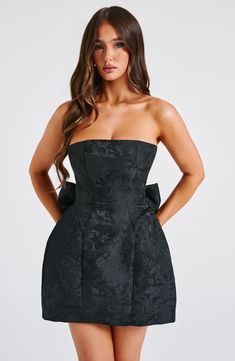 THE dress of the season has landed and you're going to be obsessed. Meet Elenora. our dreamy mini with a pretty structured skirt and waist cinching bodice. This strapless style is complete with lace up and an oversized bow to the back for perfect feminine drama.   Colour: Black. Premium non-stretch floral jacquard. Strapless design. Waist cinching. Detachable bow. Oversized bow detail to back. Voluminous. structured skirt. Lace up to the reverse. Mini length. Model is an XS and is wearing an XS. Model is an F-cup size. Structured Skirt, Dresses Flowy, Satin Homecoming Dress, Maxi Dress Sale, Sparkle Dress, Floral Jacquard, Formal Dresses Prom, Evening Attire, Prom Party Dresses