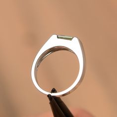 It is a green sapphire ring. The main stone is 5 mm*7 mm emerald cut.weight about 1.20 carats. The basic metal is sterling silver and plated with rhodium/14k white gold/14k rose gold/14k yellow gold You can also go to my shop Home for more elegant rings: https://www.etsy.com/shop/godjewelry?ref=hdr_shop_menu Customization is always welcome and please feel free to contact with me if you have any design ideas! Modern Emerald Ring With Vvs Clarity And Baguette Cut, Modern Baguette Cut Emerald Promise Ring, Modern Emerald Cut May Birthstone Jewelry, Modern Baguette Cut Emerald Ring For May Birthstone, Green Emerald Cut Ring With Tension Setting, Modern Emerald Cut Emerald Ring With Tension Setting, Formal Emerald Cut Emerald Ring With Tension Setting, Modern White Gold Emerald Ring With Asscher Cut, Modern Silver Emerald Cut Ring