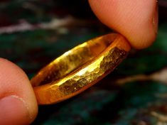 "This is a solid gold ring constructed using pure 24k gold.  I start with refined .999 pure gold and melt it to red hot liquid metal, then forge it into a bar which is painstakingly rolled and hammered into the finished ring you see. The brilliance of pure 24k (99.9% gold content) gold is unmistakable. The rich color stands out from most standard jewelry that is made from 14k (58.3% gold content) and 18k (75% gold content) jewelry. The band has a hammered flat profile, so it is flat on the insid Gold Hammered Promise Ring, Hammered Gold Jewelry For Promise, Gold Hammered Jewelry For Promise, Gold Hand Forged Round Band Rings, Hand Forged Gold Engraved Promise Ring, Handmade 22k Gold Ceremonial Rings, Handmade 22k Gold Rings For Ceremonial Occasions, Gold Hammered Engraved Ring For Promise, Gold Hammered Engraved Promise Ring