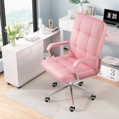 a pink office chair sitting on top of a rug in front of a white desk