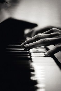 a person's hand on the keys of a piano