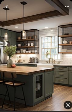 a large kitchen with green cabinets and wooden counter tops, along with an island in the middle