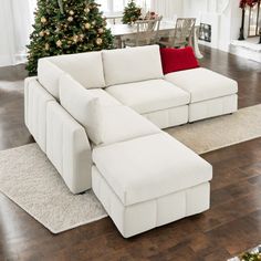 a living room with a white couch and christmas tree