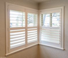 an empty room with white shutters on the windows