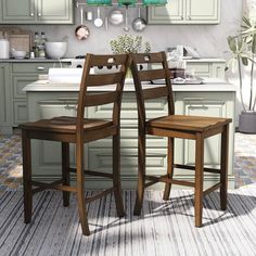 two wooden chairs sitting in front of a kitchen counter