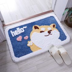 a door mat with a cartoon cat and hello kitty written on it, next to slippers