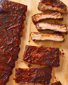 barbecue ribs are lined up on a cutting board with bbq sauce and seasoning