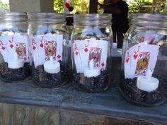 four mason jars with playing cards in them