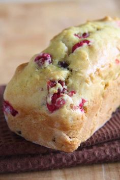 a loaf of bread with cranberry toppings sitting on top of a table