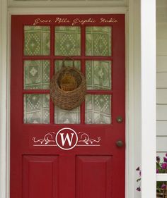 a red front door with the letter w on it and a basket hanging from the side