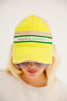 Introducing the WISHFUL DINKING NEON DISTRESSED HAT - the perfect hat for those who don't take themselves too seriously. This fun and quirky hat features a neon distressed design and a gold and green striped ribbon with a playful Wishful Dinking design. Stand out from the crowd and add a touch of humor to your wardrobe with this one-of-a-kind hat! All orders are currently shipping within 14 business days. To receive item quicker, expedited shipping is available at checkout. Distressed Green Cap Hat, Green Distressed Cap, Distressed Green Cap, Softball Cheer, Golf Party, Gold Hats, Distressed Hat, Cheer Dance, Jolly Santa