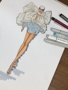 a drawing of a woman in short shorts and jacket with heels on her feet, next to markers