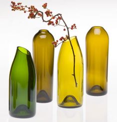 three green vases sitting next to each other in front of a white background with red flowers