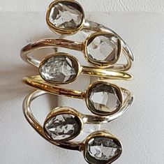 a gold and silver ring with clear stones on it's sides, hanging from the wall