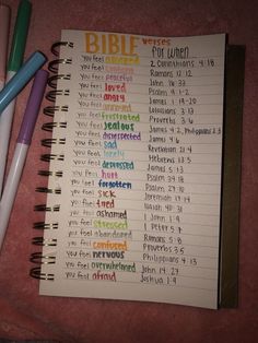 a notebook with the words bible written on it and three pens next to it, all in different colors