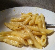 a white plate topped with pasta on top of a table