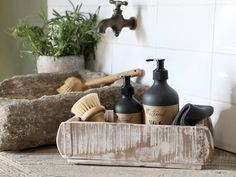 soap, lotion and scrubs are sitting in a wooden box on the counter