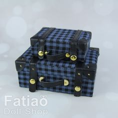 two black and blue plaid suitcases sitting next to each other on a white surface