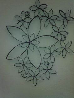 a metal wall hanging with flowers and leaves on it's side, in the shape of a circle