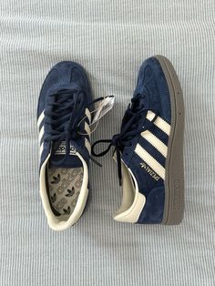 a pair of blue adidas sneakers sitting on top of a bed