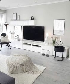 a living room with white furniture and a flat screen tv