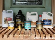 the bottles are lined up on the wooden table with different types of cleanery products