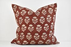 a red pillow with white flowers on it