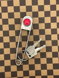 a pair of keys sitting on top of a checkered floor with a red light