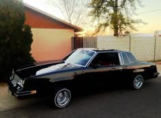 a black station wagon parked in front of a house