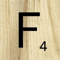 the letter f is made out of wood and has black letters on it's sides