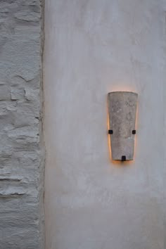 a light that is on the side of a wall next to a cement block and brick