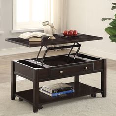 a coffee table with an open drawer underneath it and some books on the top shelf